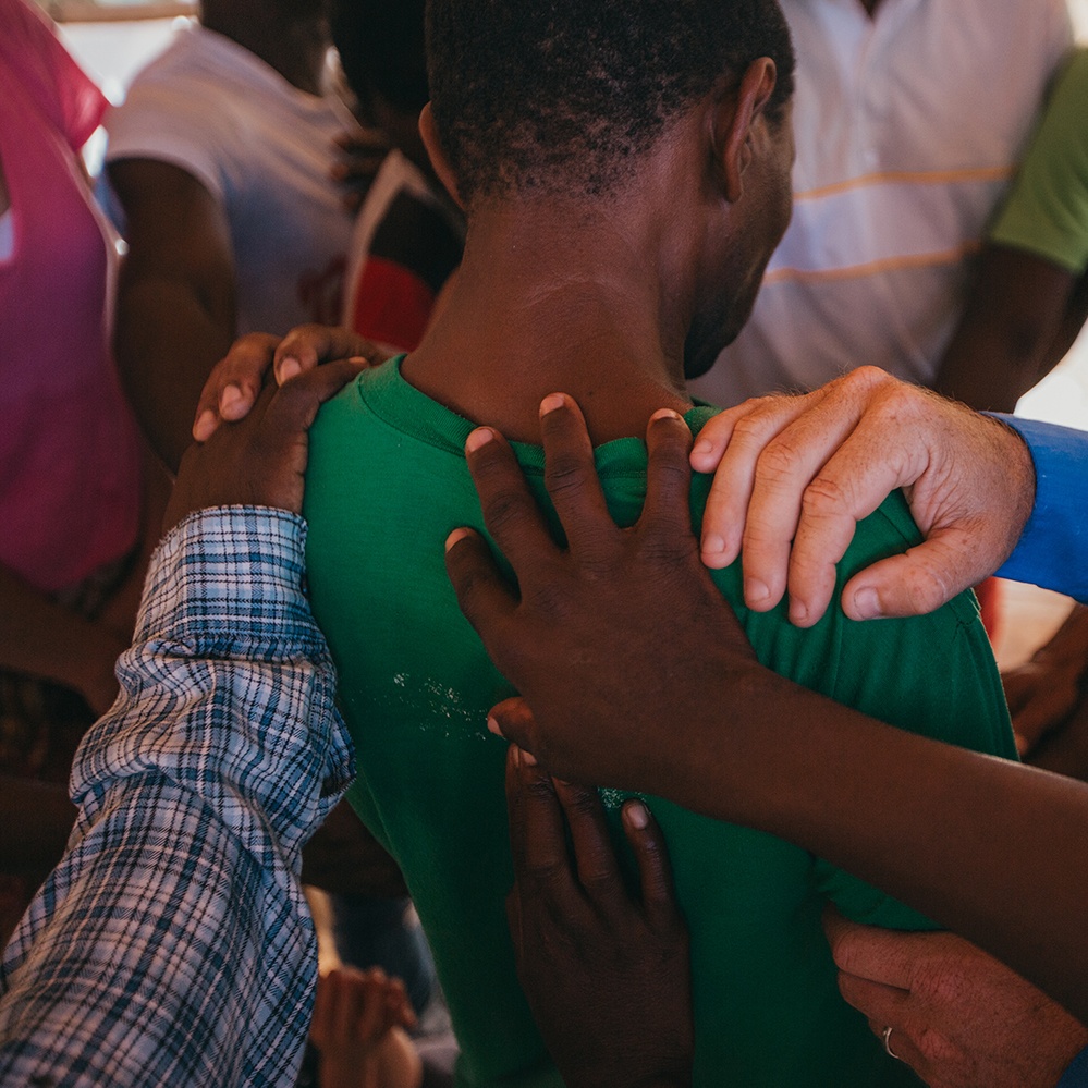 People praying over a church member